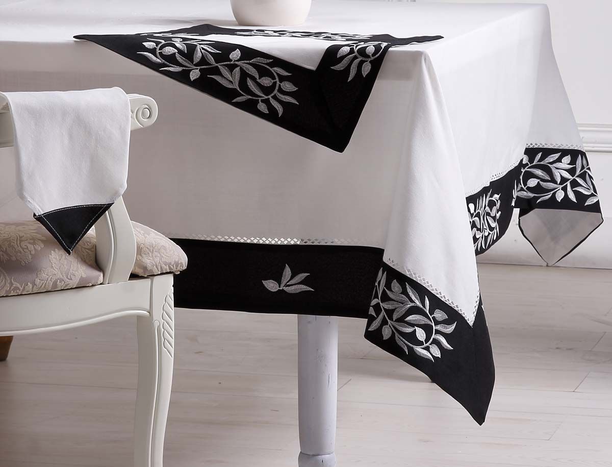 Embroidered black and white table linens arranged on a table